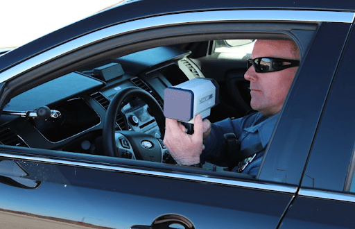 Policeman Holding radar in car